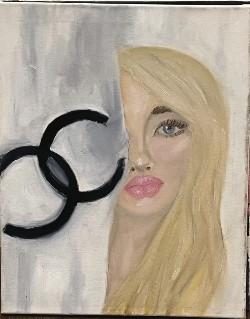 A blonde figure beside a black double C mark on a grey and white ground.