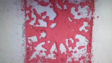 A phone recording of a faceted red form breaking into a perforated surface.